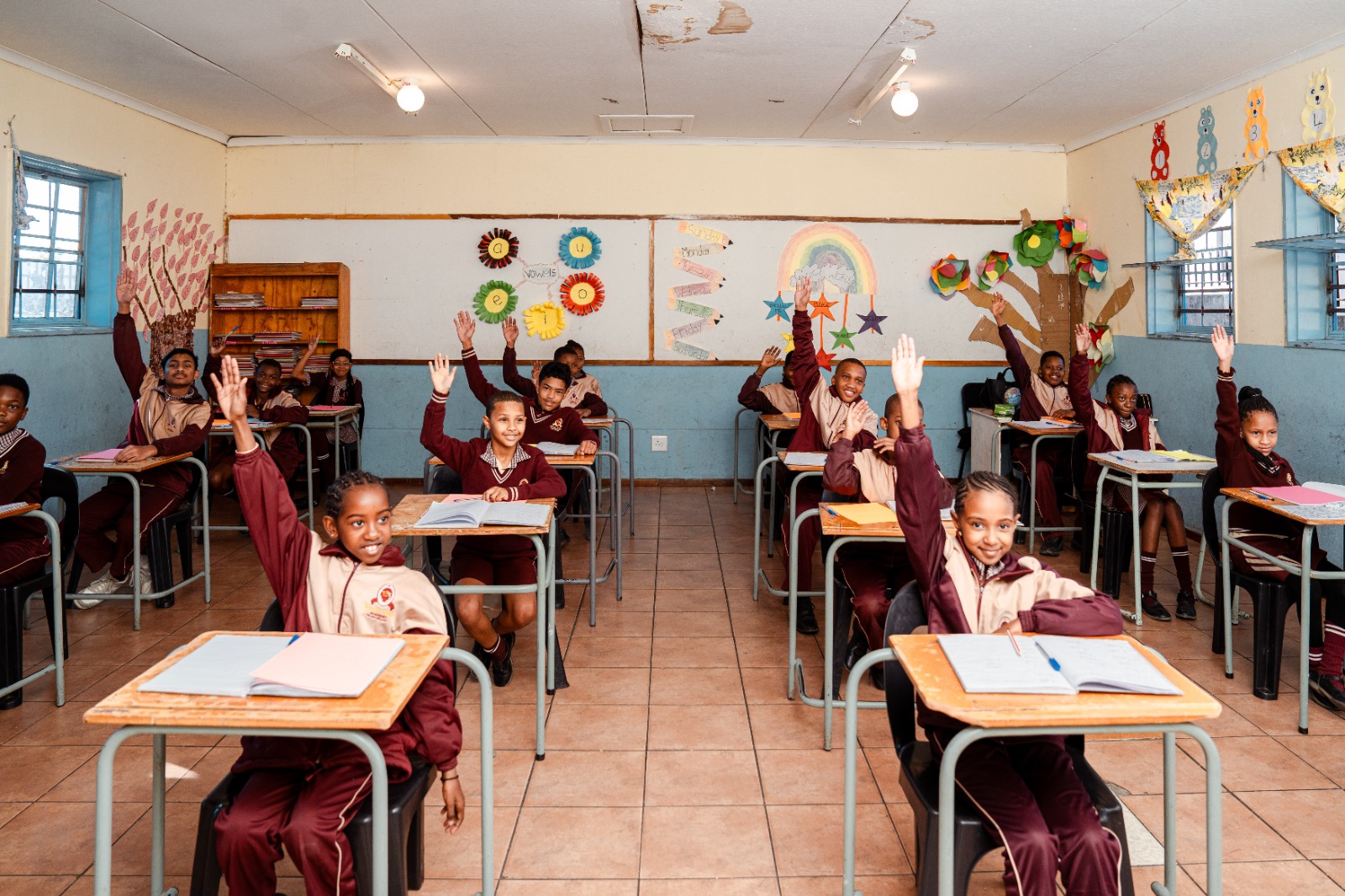 Pupils raise their hands during a classroom lesson