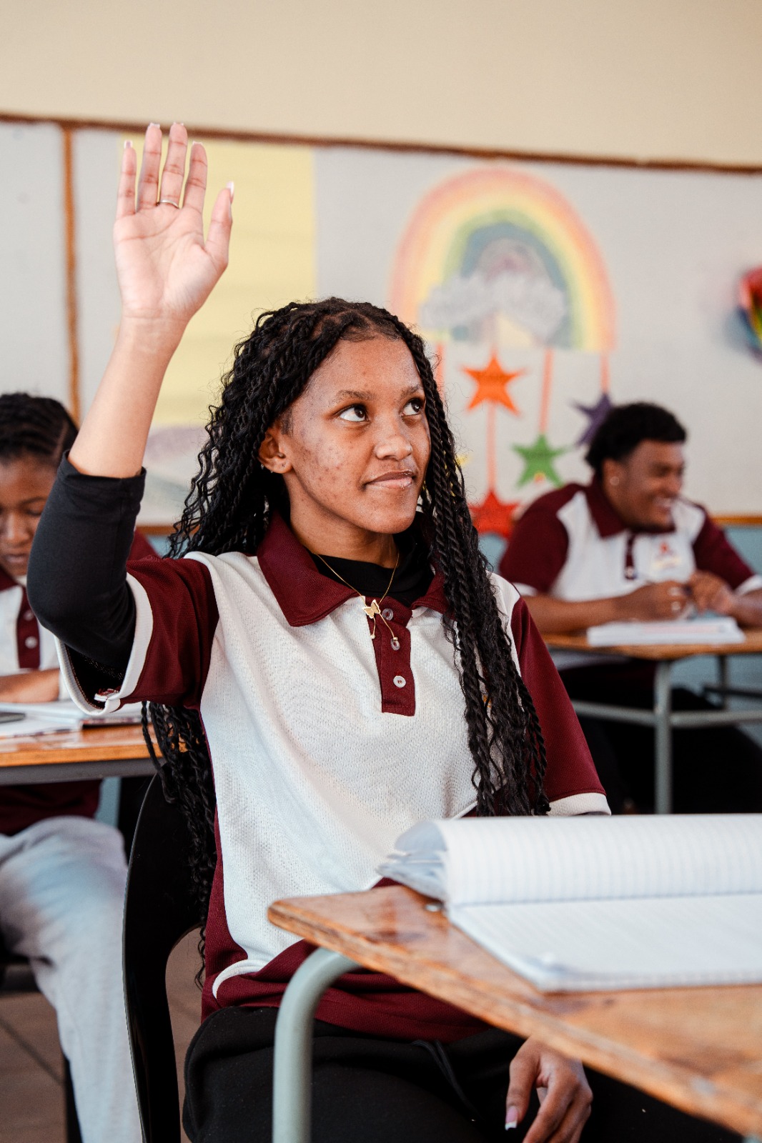 A pupil raises her hand to answer a question